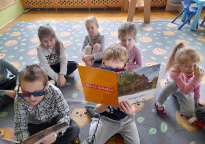 Dzieci oglądają plansze z dinozaurami w 3D